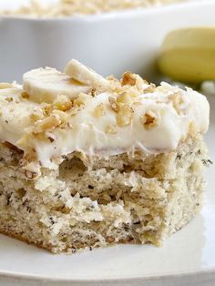 a close up of a piece of cake on a plate with bananas in the background