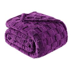 two purple towels stacked on top of each other in front of a white background,