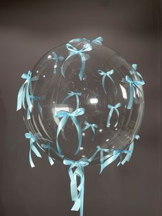 a clear ball with blue ribbons on it