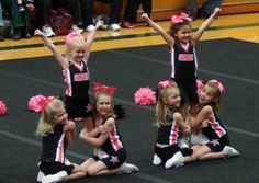 the cheerleaders are sitting on the floor with their arms in the air