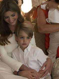 the young boy is sitting on his mother's lap