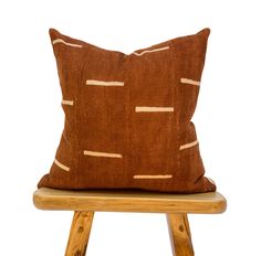 a brown pillow sitting on top of a wooden stool