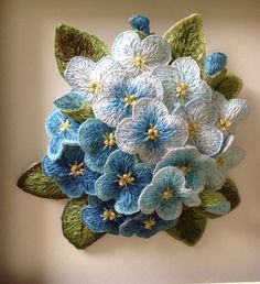 a blue and white flower arrangement hanging on the wall