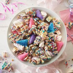 a white bowl filled with lots of sprinkles next to confetti