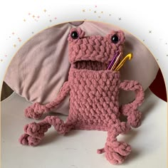 a crocheted pink stuffed animal holding a toothbrush