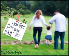 a man and woman holding hands while walking with a small child in a grassy field