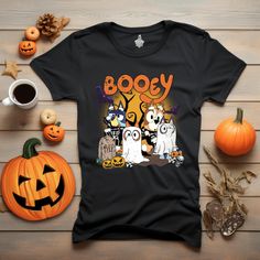 a black shirt with booy on it next to pumpkins and other halloween items