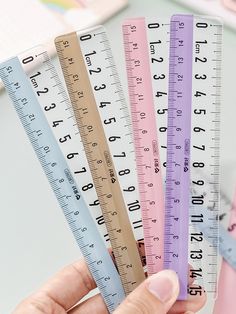 a person is holding four rulers in their left hand and the other one has a ruler on it