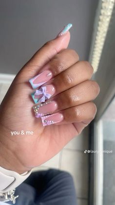 a woman's hand with some pink and blue nail polishes on her nails