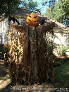 a scarecrow with a jack - o'- lantern on his head and arms