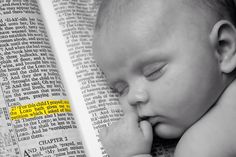 a baby laying on top of an open book with its head resting on his hands