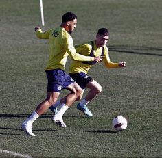 two men are playing soccer on the field