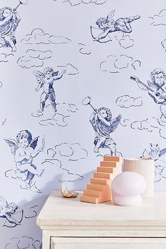 the wallpaper is blue and white with cherubs in the clouds on it