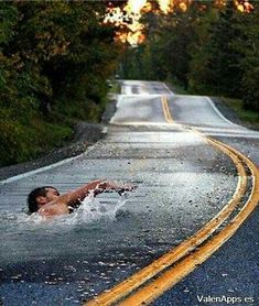 a man swimming in the middle of a road