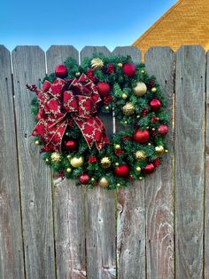 a christmas wreath hanging on a wooden fence