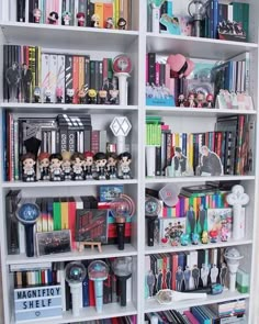 a white bookcase filled with lots of books and other items on top of it