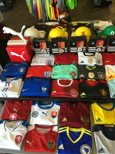 many soccer jerseys are on display in a store