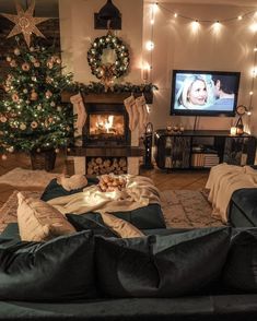 a living room filled with furniture and a christmas tree in front of a flat screen tv