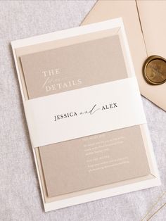 the wedding stationery is laid out on top of an envelope with a penny in it