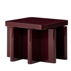 a red table with three legs and two small tables on each side, all in the same color