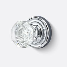 a glass door knob with an intricate design on the top and bottom, set in polished chrome