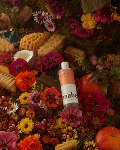 an orange tube sitting on top of a pile of flowers and other colorful items next to it