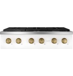 a white stove top with four brass knobs