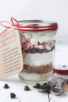 a mason jar filled with marshmallows, peppermint and chocolate candy