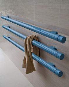 a towel hanging on the side of a wall next to some blue pipes and hooks