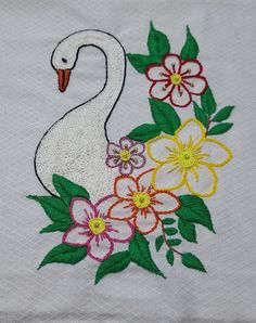 a white swan with flowers on it's chest is embroidered onto a piece of cloth