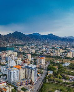 an aerial view of a city with mountains in the background