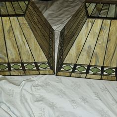 two stained glass lamps sitting on top of a bed