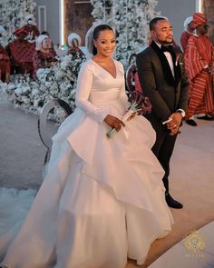 the bride and groom are standing in front of a christmas tree