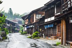 an empty street lined with wooden buildings in the rain