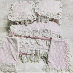 four pieces of pink and white ruffled bedding laid out on the floor next to each other