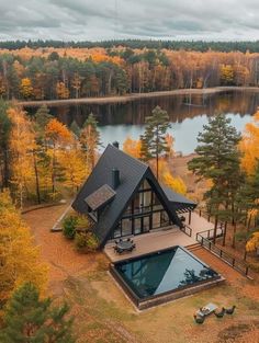 an aerial view of a house with a pool in the foreground and trees surrounding it