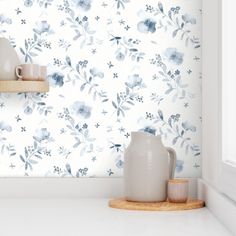 a white vase sitting on top of a wooden shelf