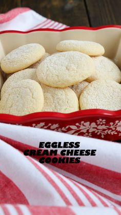 some cookies are in a red and white dish on a table with the words eggless cream cheese cookies