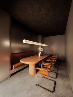 a long wooden table sitting in the middle of a room with four chairs around it