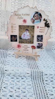 a photo frame with pictures on it sitting on top of a white cloth covered table