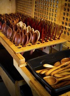 many wooden spoons are lined up on a shelf