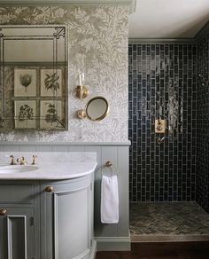 a bathroom with a sink, mirror and tiled shower stall in the middle of it