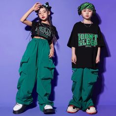 two young children standing next to each other wearing green pants and black shirts with the words don't sleep printed on them