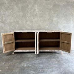 two wooden cabinets sitting side by side in a room with concrete flooring and walls