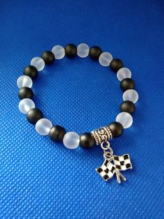 "You will love this stretch beaded bracelet designed with black and white frosted 8mm glass beads along with a black and white checkered flag charm.  The stretch will fit most sizes and is approximately 7\" prior to tie closure.  If you need a different size, please send me a message. My shop offers combined shipping.  Purchase multiple items on one invoice and pay one flat shipping fee.  This is a great deal for shoppers! All items in my shop intended for adults. All items in my shop contains s Flag Beads, Flag Bracelet, Golf Lover Gifts, Patriotic Jewelry, Flat Beads, Bracelets Handmade Diy, Chandler Az, Beads Designs, Checkered Flag