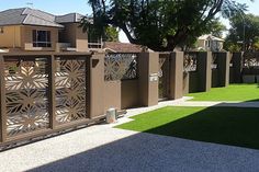 an artificial grass yard with fenced in areas and trees on the other side, surrounded by houses