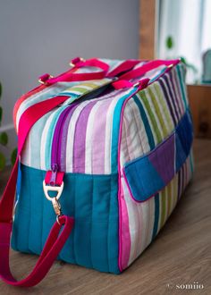 a multicolored bag sitting on top of a wooden floor