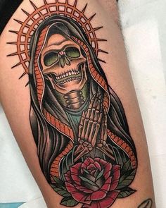 a woman's thigh with a skeleton and rose tattoo on it