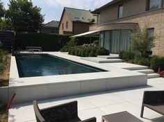 an outdoor swimming pool surrounded by lawn furniture