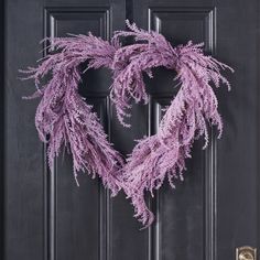 a heart shaped wreath hanging on the front door